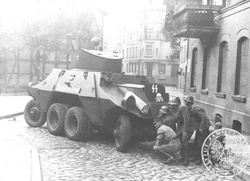 Żołnierze niemieccy kryjący się za samochodem pancernym ADGZ (ex. austriackim) "Sudetenland" podczas ataku na Pocztę Polską przy Placu Heweliusza. (sygn. IPN BU 3040/1, k. 6/1)